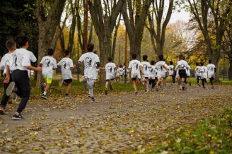 A group of kids participating in a running event in a leafy park in Bursa, Türkiye.